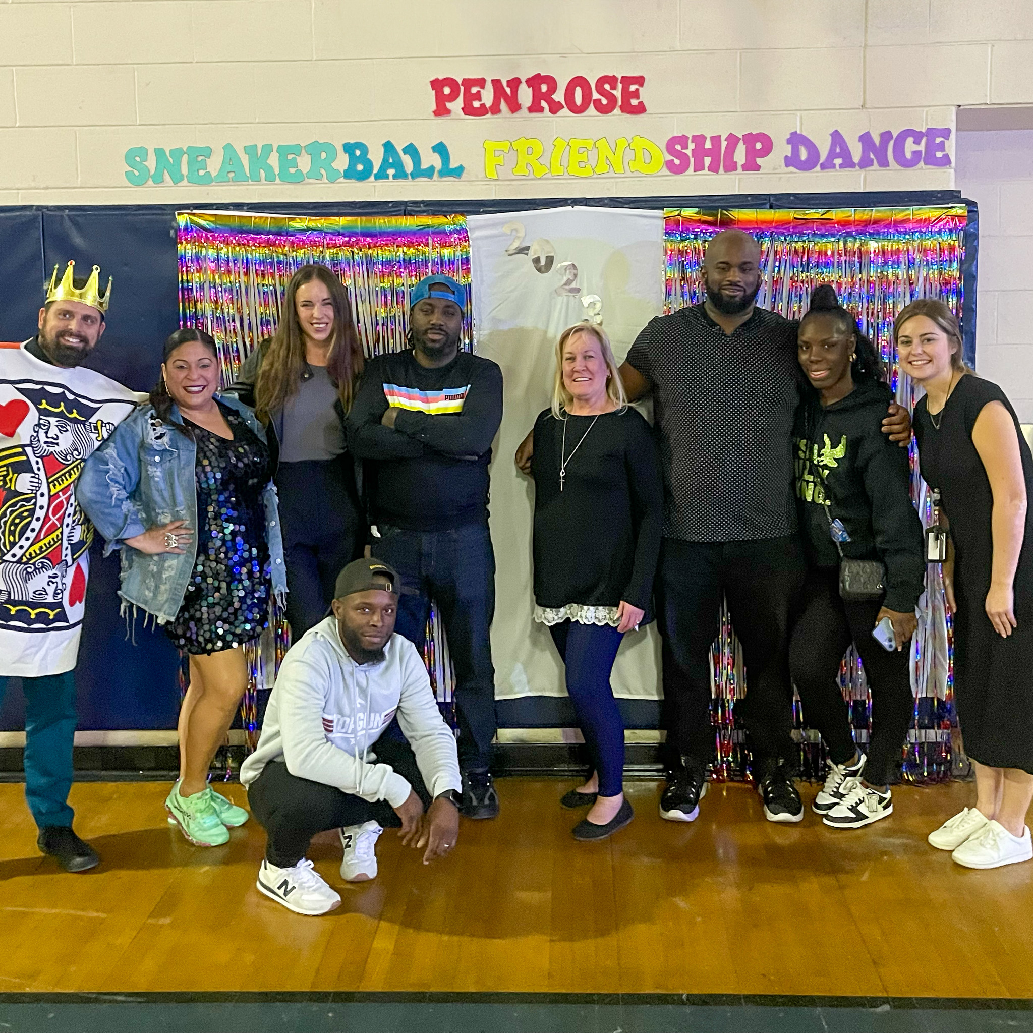 Penrose Staff at Sneakerball Friendship Dance Group of Penrose School staff posing together at the Sneakerball Friendship Dance in front of a colorful backdrop.