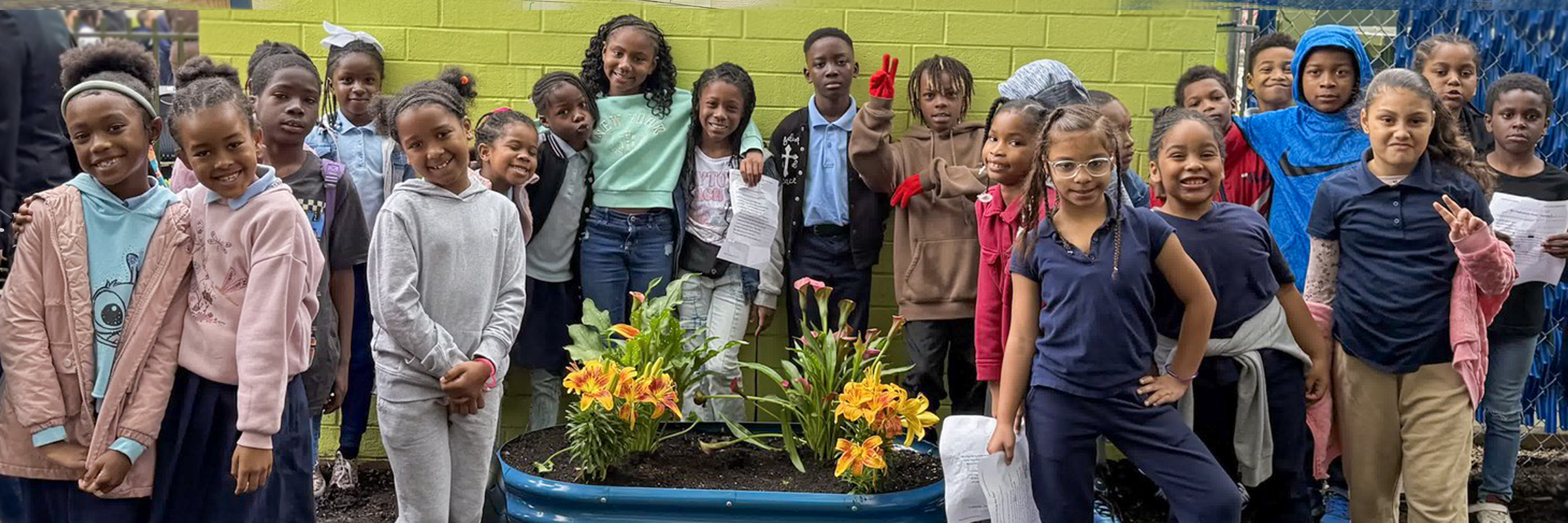 Group of Penrose elementary school students posing near flower planter